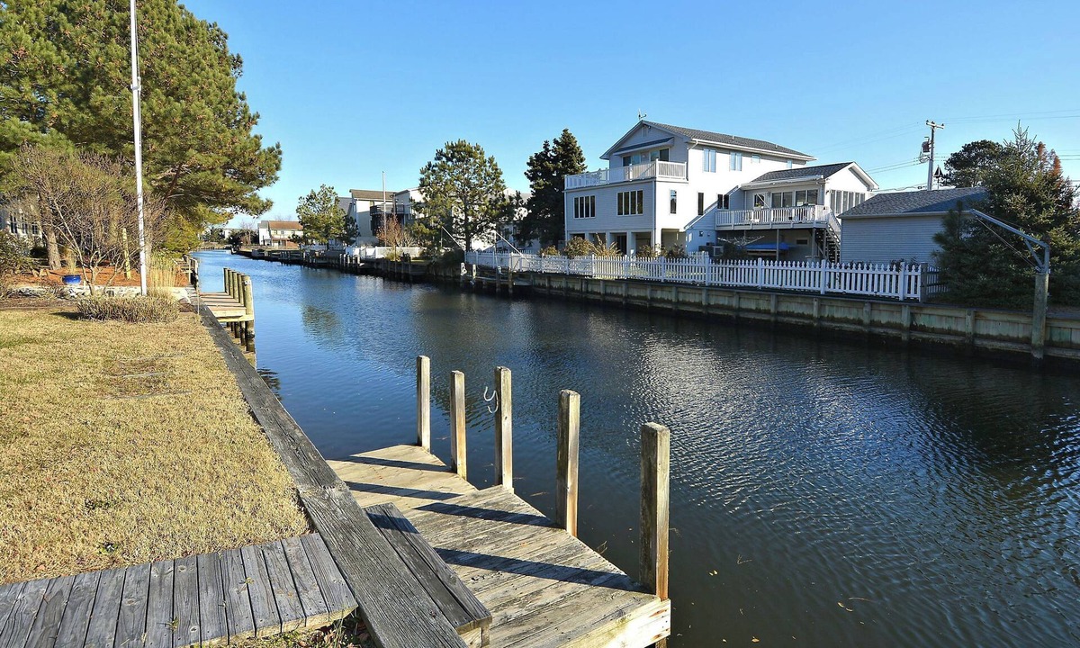 Sandpiper Pines House | FREE DAILY ACTIVITIES!! Lovely 4 bedroom + Den, (Two Master Bedrooms) 3.5 bath home, located on the canal, with boat dock, 2 car garage,just a short walk to the lifequarded beach.