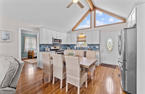 Colington Harbour House | Dog-friendly home with canal views, dock, kayaks, sunroom, deck, & firepit