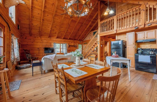 Floyd House | Peaceful log cabin retreat with wraparound deck, open living space, full kitchen, cozy bedrooms & scenic wooded views.