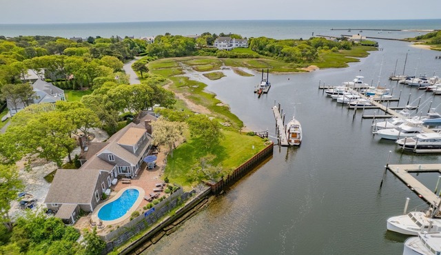 Nautical retreat with water views, inground heated pool, and private beach access